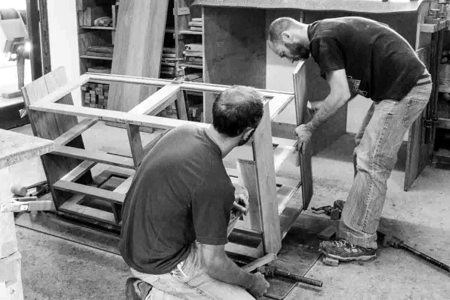 Austin and Aaron assembling cabinet ends to shelves