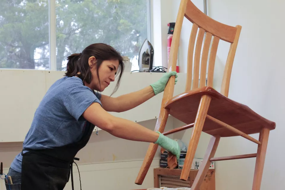 Audra finishing a dining chair