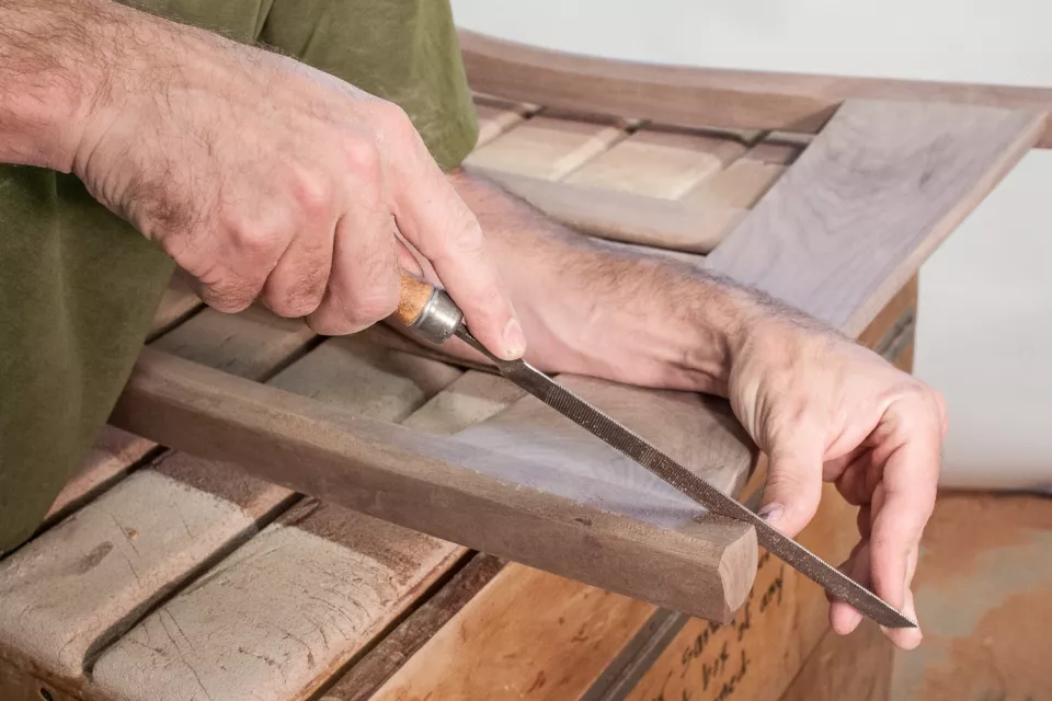 close up of sculpting a bevel on rocking chair crest