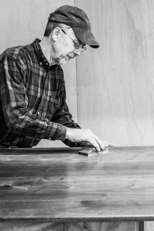 Gary sanding a table top between coats of finish