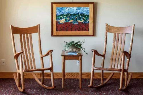 two rocking chair, a side table, and a painting