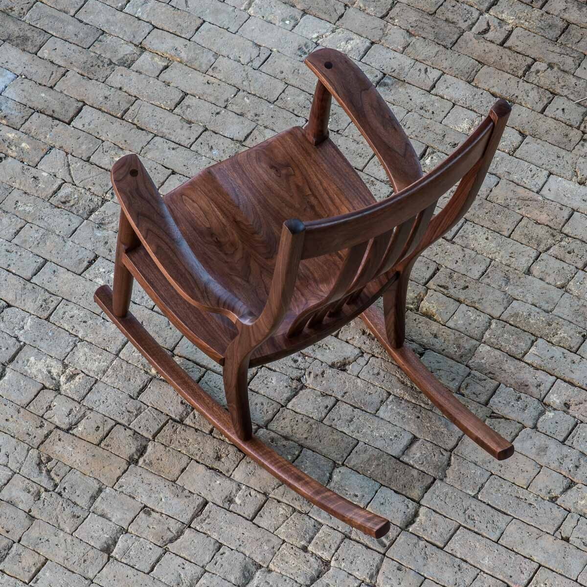 walnut rocking chair on brick floor