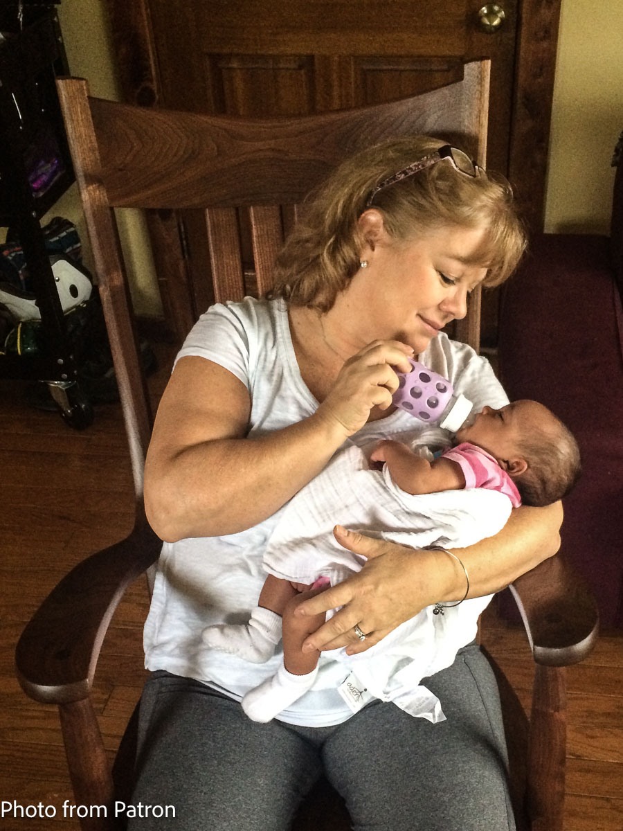 grandmother feeding grandchild in rocking chair